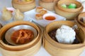 Closeup deep Chinese steamed red pork bun break can see pork inside and  red sauce spare ribs pork in bamboo basket in dim sum set Royalty Free Stock Photo