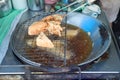 Closeup deep fried taro and tofu in the boiled oil with steel pan and tools. Vegetarian food and festival