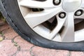 Closeup of deflated flat car tire due to rupture at the side of the wheel