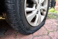 Closeup of deflated flat car tire due to rupture at the side of the wheel