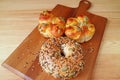 Multi grains and sesame bagel and rolls on wooden breadboard Royalty Free Stock Photo