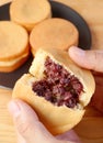 Delectable Split Japanese Azuki Bean Paste Filled Dessert Called Imagawayaki or OBanyaki in Hands