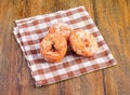 Closeup of delicious anise donuts on a checkered cloth over a wooden table