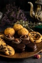 Closeup of delicious cookies on a wooden plate with an old teapot on table Royalty Free Stock Photo