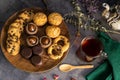 Closeup of delicious cookies on a wooden plate with an old teapot on table Royalty Free Stock Photo