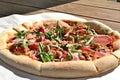 Closeup of a delicious freshly baked pizza with prosciutto on a table Royalty Free Stock Photo