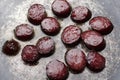 Closeup of delicious fried pieces of sausages on the dark pan.Process of cooking