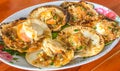 Closeup Delicious grilled scallops with butter and spicy sauce on the shell on wood table background, Asian Thai seafood Royalty Free Stock Photo