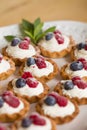 Closeup of delicious homemade cupcakes with vanilla cheese cream and organic blueberries and raspberries Royalty Free Stock Photo
