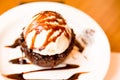 Closeup of a delicious icecream on top of a brownie with a chocolate sauce in the plate Royalty Free Stock Photo