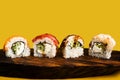Closeup of delicious japanese food with sushi roll. Four rolls of maki in a row with salmon, avocado, tuna and cucumber isolated o Royalty Free Stock Photo