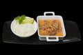 Closeup of delicious pork with sauce and a bowl of boiled rice with lemon and mint Royalty Free Stock Photo