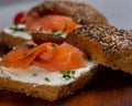 Closeup of delicious smoked salmon and cream cheese bagels, on a wooden surface