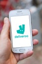 Closeup of Deliveroo logo on smartphone screen in hand from Samsung brand in the street