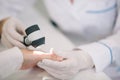 Closeup of dermatologist examining mole on hand of female patient in clinic