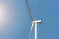 Closeup detail back view of new white modern wind turbine farm power generation station against clear blue sky on day Royalty Free Stock Photo