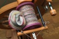 Closeup detail of a bobbin full of handspun and handdyed merino sheep wool yarn , spun on a traditional spinning wheel. Royalty Free Stock Photo
