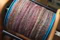 Closeup detail of a bobbin full of handspun and handdyed merino sheep wool yarn , spun on a traditional spinning wheel. Royalty Free Stock Photo