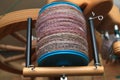 Closeup detail of a bobbin full of handspun and handdyed merino sheep wool yarn , spun on a traditional spinning wheel. Royalty Free Stock Photo