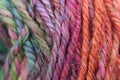 Closeup detail of colourful hand spun sheep wool merino fibres, rolled up in a yarn ball skein. Royalty Free Stock Photo