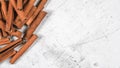 Closeup detail - Heap of cinnamon bark sticks on white stone board, empty space for text right side