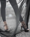 Closeup detail legs in high heeled strips shoes of woman under transparent textile