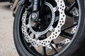 Closeup detail of racing motorcycle disk brake with ABS system and tire on road Royalty Free Stock Photo