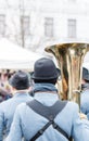 Closeup detail of retro weared standing back soldier with big brass tuba and other soldiers background Royalty Free Stock Photo