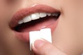 Closeup detail of woman putting pink chewing gum into her mouth. Chewing Gum, Eating, Women. Close up on a beautiful girl