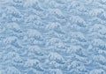 Closeup detailed photograph of traditional Japanese furoshiki depicting a pattern of a great wave in blue sea.