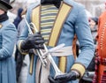 Closeup details of retro weared standing trumpeters soldier standing with brass trumpet, other soldiers background Royalty Free Stock Photo