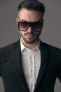 Closeup of determined fashion model wearing suit and sunglasses Royalty Free Stock Photo