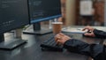Closeup of developer hands typing code on keyboard while looking at computer screens Royalty Free Stock Photo