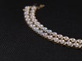 A closeup shot of a Diamond Tennis Bracelet on a black surface Royalty Free Stock Photo