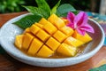 Closeup of diced mango in syrup, garnished with a pink flower and green leaves Royalty Free Stock Photo