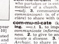 Closeup of the dictionary definition of the word communicate Royalty Free Stock Photo