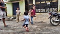 Closeup of different age group kids playing Buguri or Spinning Tops on Roadside during holiday