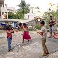 Closeup of different age group kids playing Buguri or Spinning Tops on Roadside during holiday