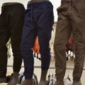 Closeup of different dark-colored sweatpants for men on mannequins at a store