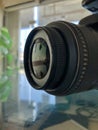 Closeup of digital camera lens side view,blurred background,photography equipment Royalty Free Stock Photo