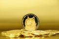 Closeup of a digital dog coin on a bunch of coins isolated on a golden background