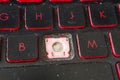 Closeup of a dirty and neglected laptop keyboard with red accents with a missing key. Covered in dust and fine hairs