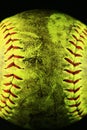 Closeup of a dirty, yellow softball with red seams. Royalty Free Stock Photo