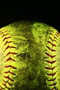 Closeup of a dirty, yellow softball with red seams. Royalty Free Stock Photo