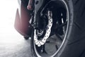 Closeup disc brake of a scooter. Aluminum alloy wheel of motorcycle. Steel rims. Mag wheels of motorbike. Performance wheel and