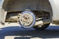 Closeup of disc brakes of a car raised by a jack without a wheel in tire service Royalty Free Stock Photo