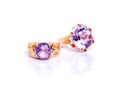 Closeup display of two exquisite rings adorned with gleaming amethyst stones, elegantly positioned on a pure white backdrop