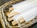 Closeup of disposable chopsticks made from balsa wood in a cane basket in a Japanese restaurant