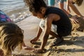 Closeup of diverse kids playing with the sand together at the be Royalty Free Stock Photo