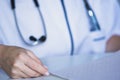 Closeup of doctor analyzing an electrocardiogram at his desk, cardiologist reading patient`s electrocardiogram